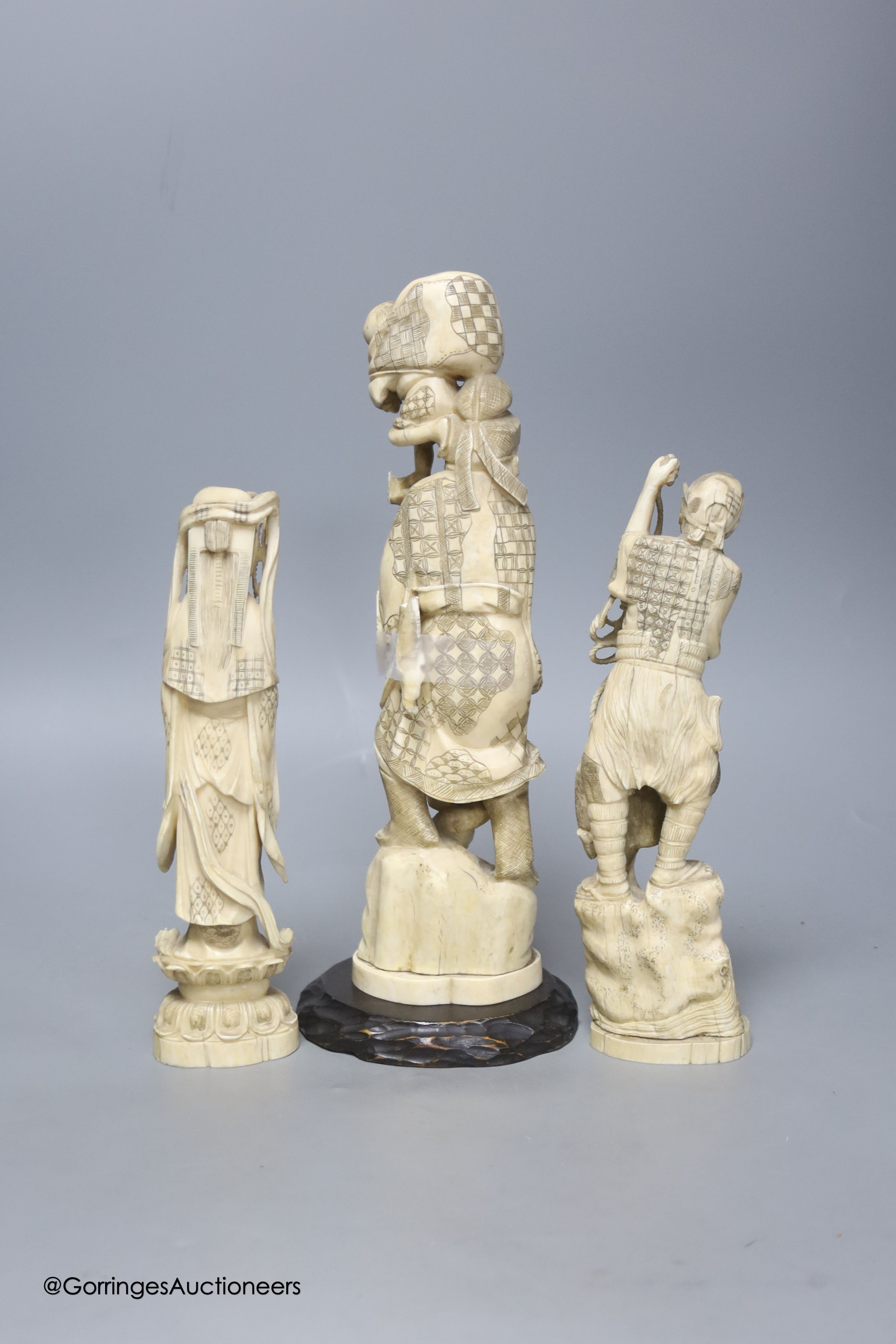 Three Japanese carved walrus ivory okimono, early 20th century, tallest 32cm including wood stand